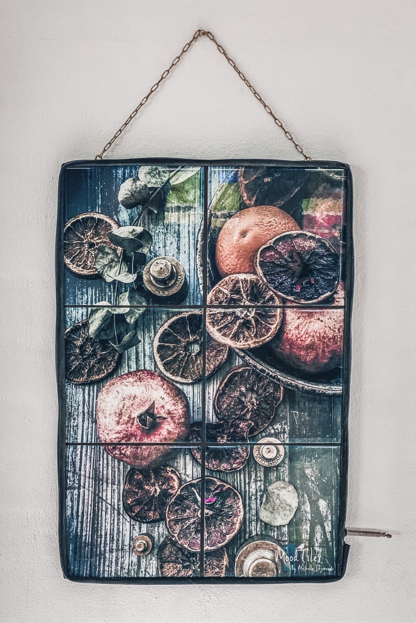 smuk flisebillede fra MoodTiles som forestiller appelsiner og granatæbler som ligger i en gammel kopper gryde. Meget rustikt og unikt fotografi. Perfekt til din billedvæg. Billede af køkkenredskaber. Mål 30x45cm